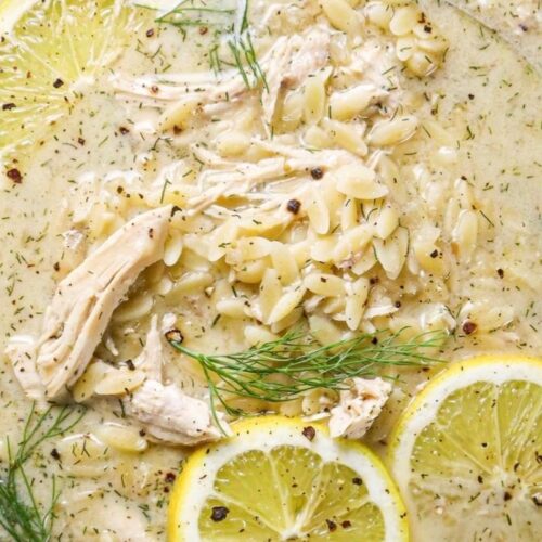 Close up of avgolemono with fresh dill, fresh lemon, orzo pasta, and chicken.