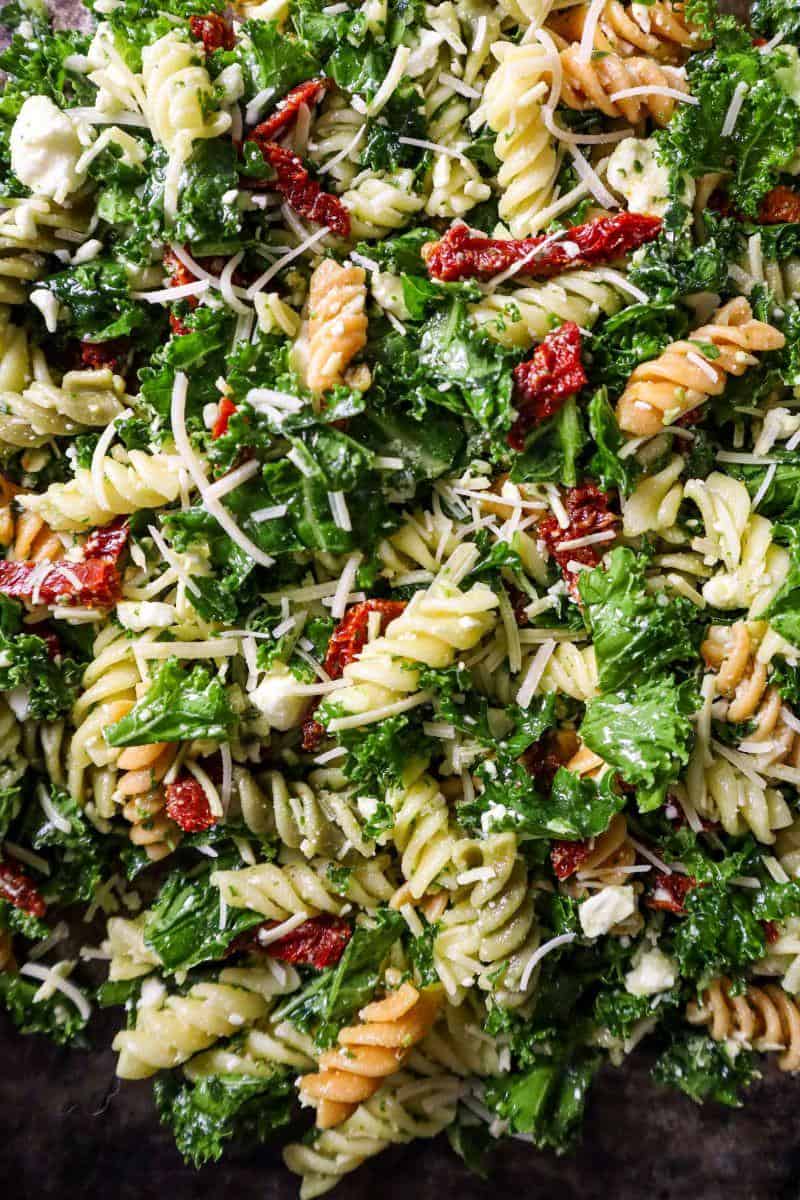 Close up of Mediterranean Pasta Kale Salad with Parmesan cheese, feta, and sun-dried tomatoes.