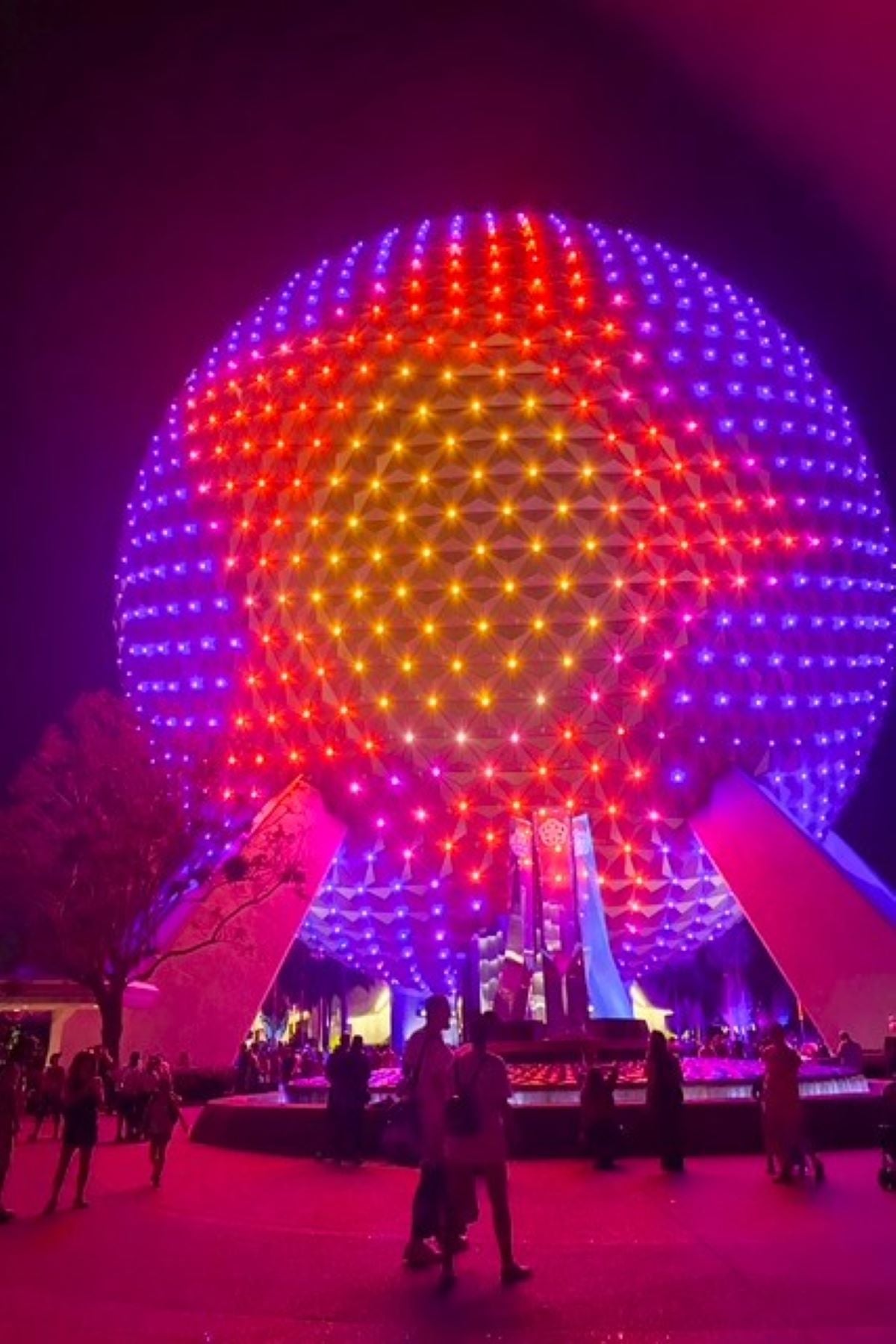 spaceship earth lit up at night